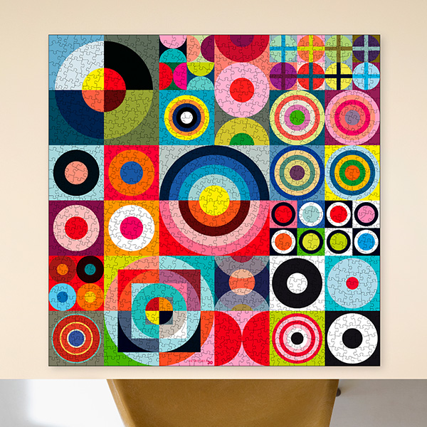 Um grande puzzle montado com padrão geométrico abstrato e vibrante. Composto por muitos quadrados com círculos coloridos, anéis concêntricos, semicírculos e quartos de círculo em cores vivas, como vermelho, azul, verde, amarelo, rosa e preto.
