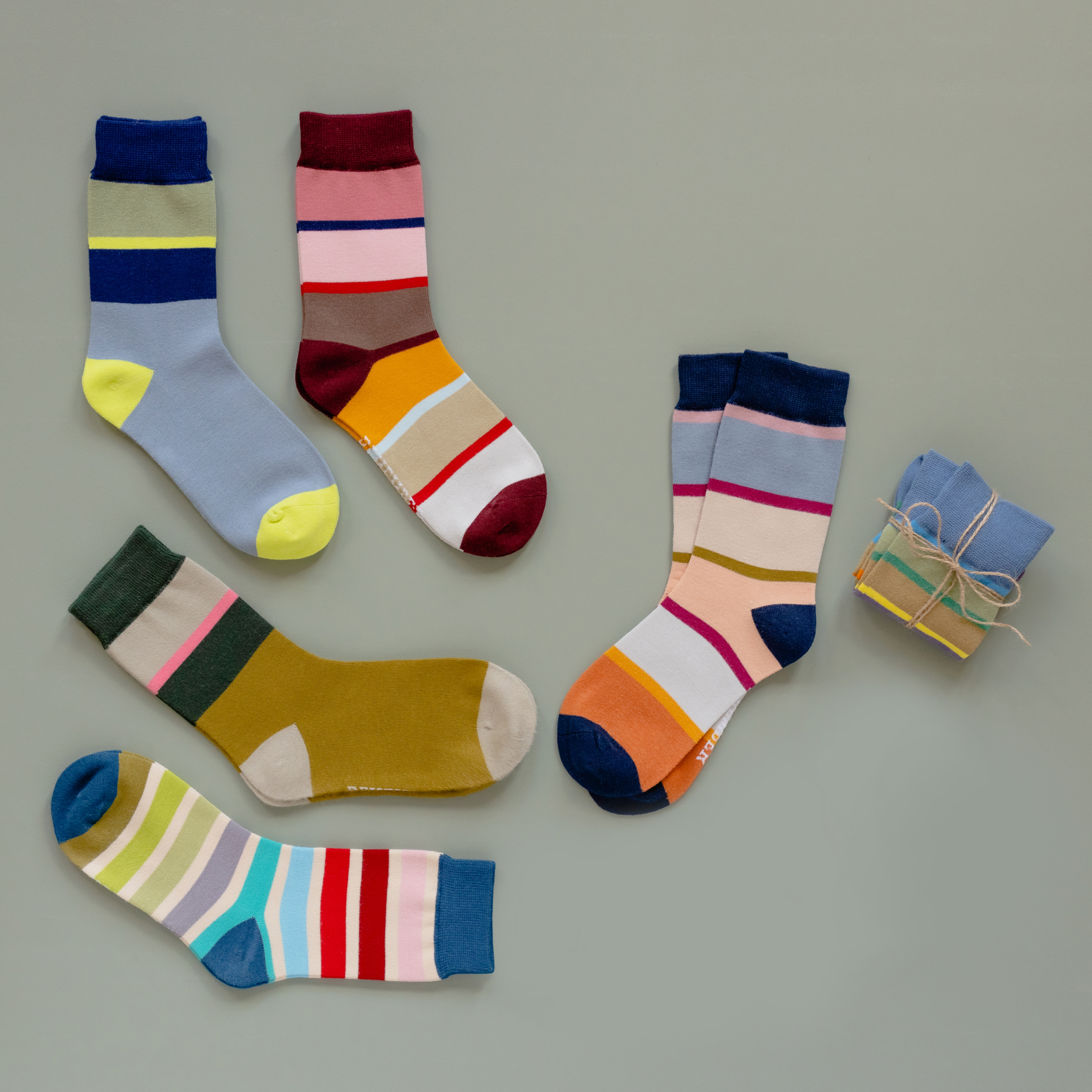 Calcetines de rayas de colores en diferentes diseños y colores; algunos vienen atados por pares con un cordón.