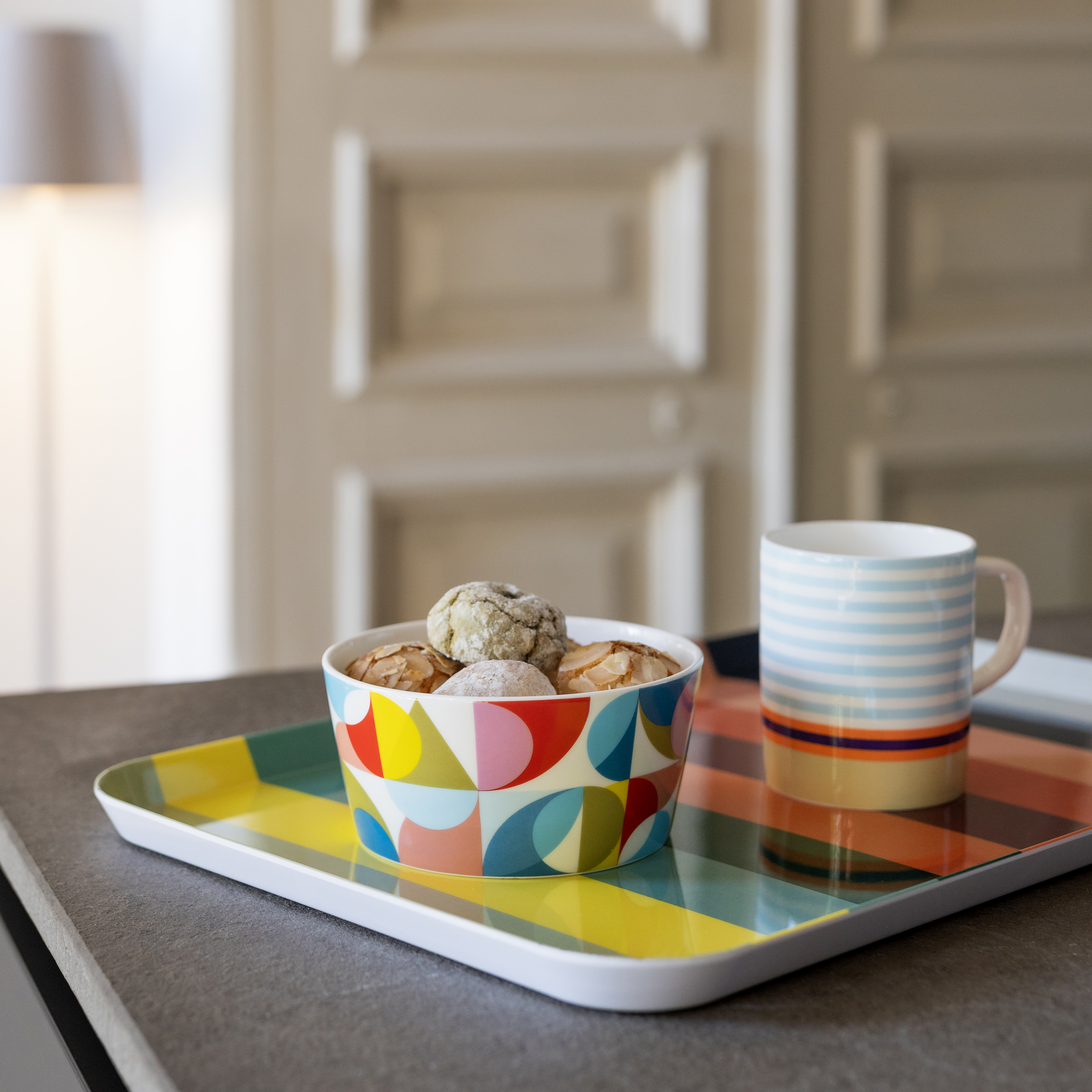 Un cuenco para cereales llamado «Solena» con un estampado geométrico de colores, formado por círculos y cuadrados en azul, amarillo, rojo, rosa, verde y negro.
