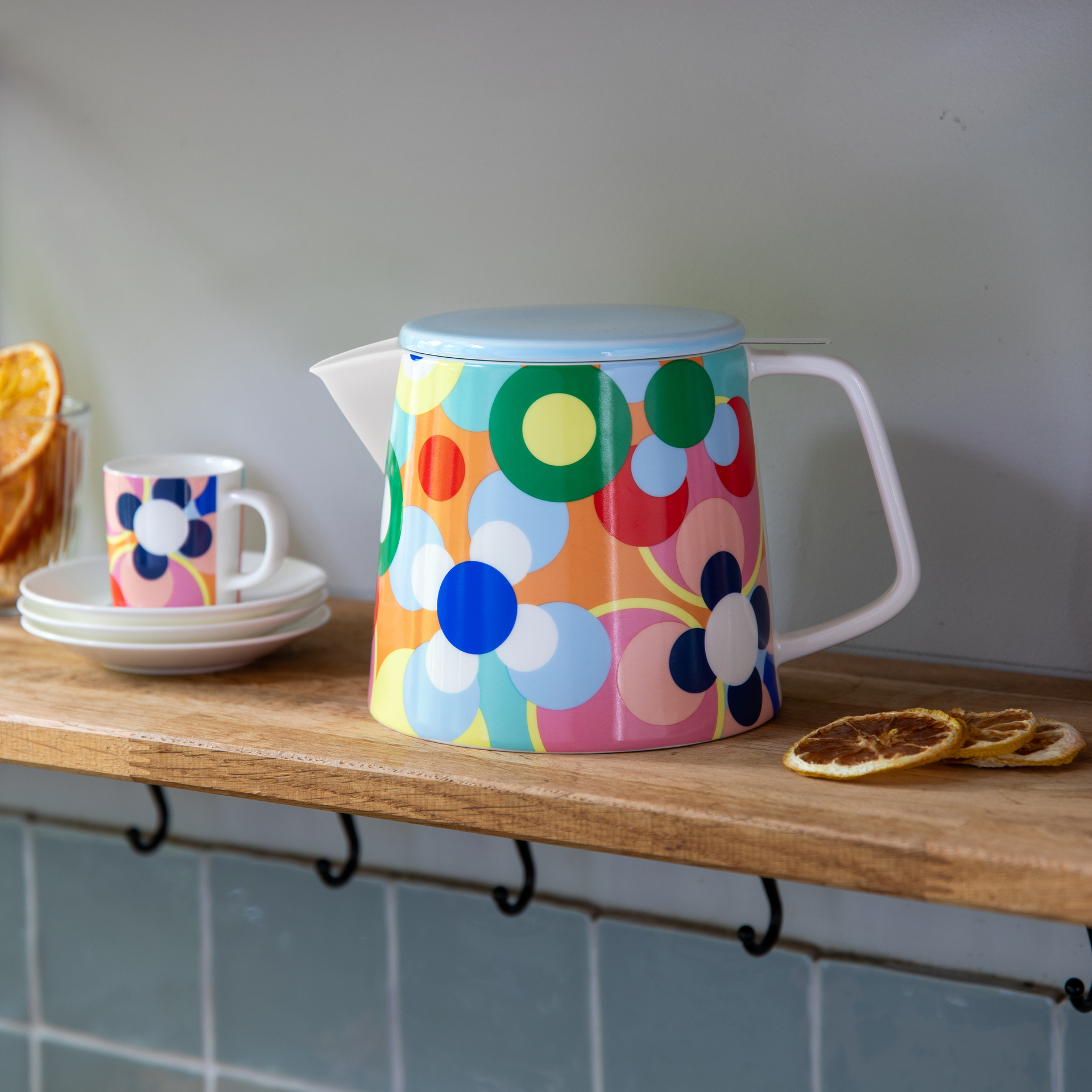 'Sushi' Teiera: teiera in ceramica con coperchio blu, manico bianco e motivo floreale colorato.