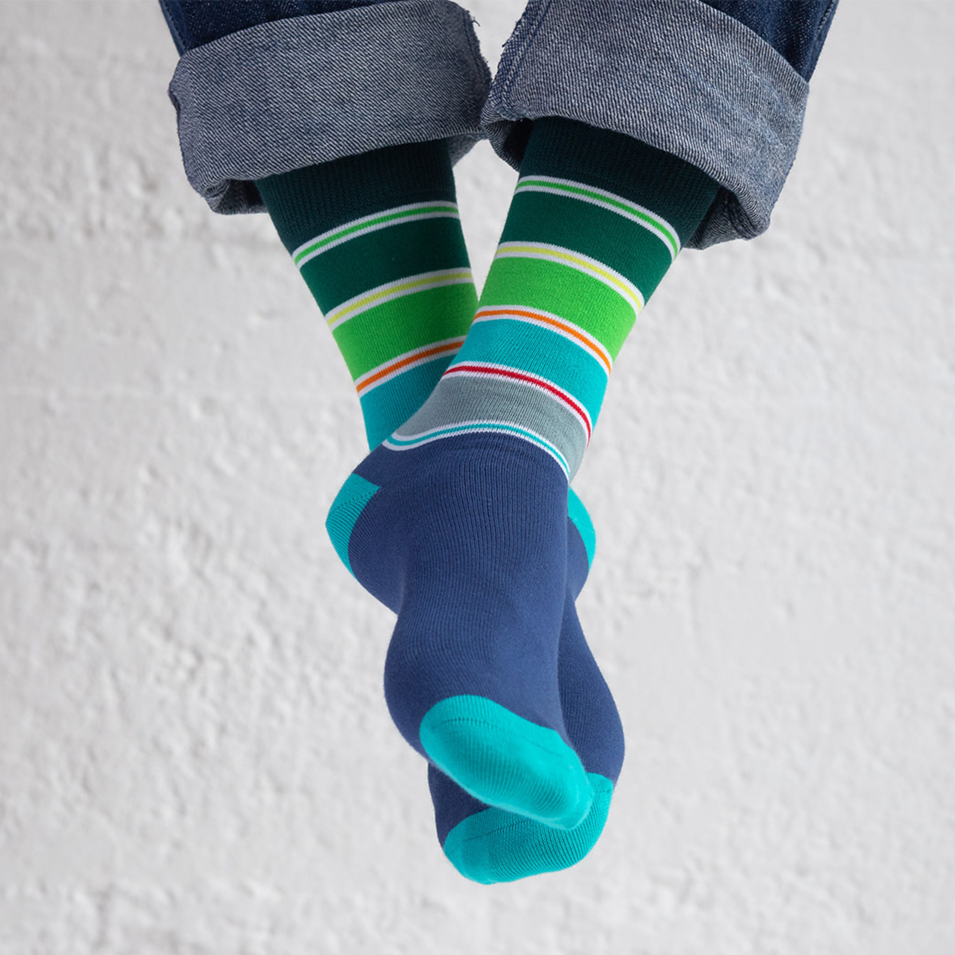 Two socks size 41-46 with a blue foot section and turquoise toe area. The cuff is dark green with coloured stripes in green, yellow, red and grey.
