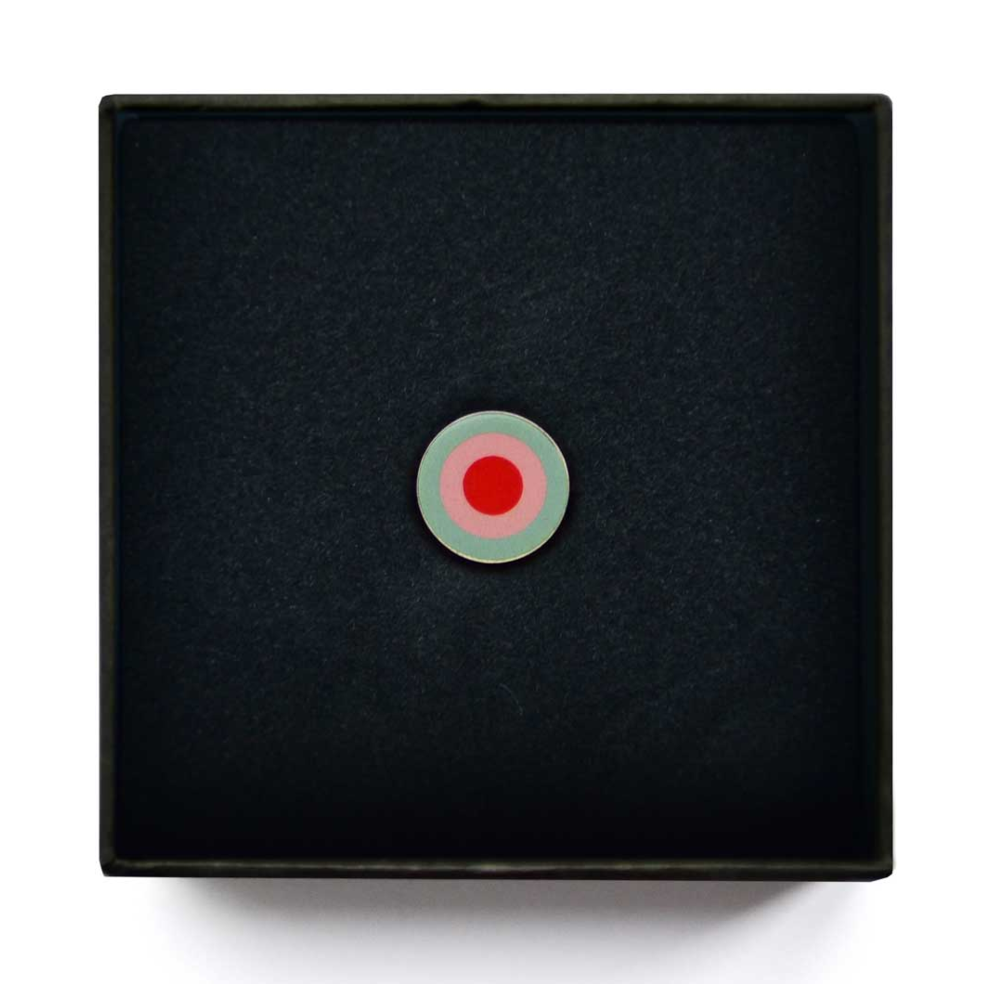 Scatola portagioie nera con ciondolo circolare rosso, rosa e verde al centro.