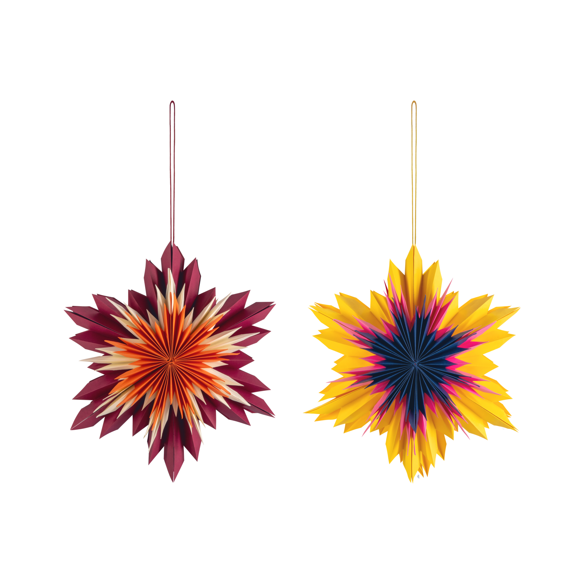 Dos estrellas decorativas de papel del juego Nova con lazo para colgar. A la izquierda, rojo oscuro con centro en tonos naranja y crema; a la derecha, amarillo brillante con centro en azul oscuro y magenta. Diseño plegado detallado.