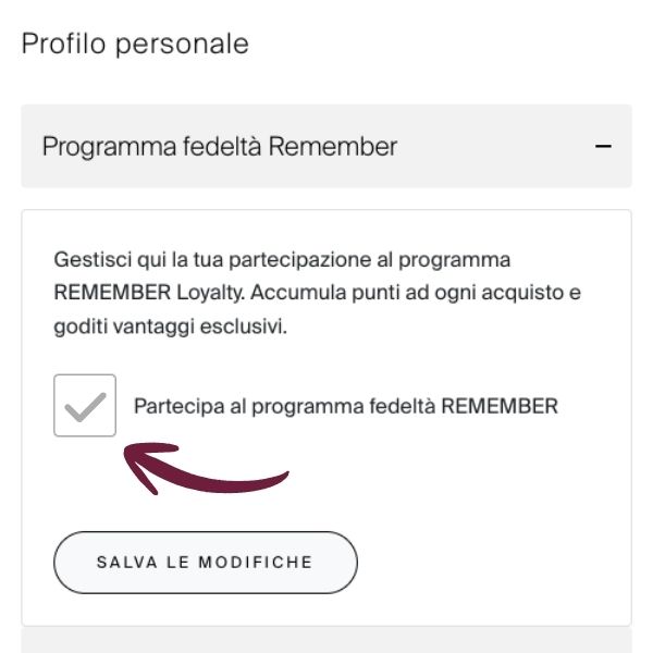 Schermata del profilo con la sezione «Programma fedeltà REMEMBER» aperta. Descrive il programma e mostra l'opzione «Partecipa al programma fedeltà REMEMBER» deselezionata, indicata da una freccia rossa. In basso, «Salva modifiche».