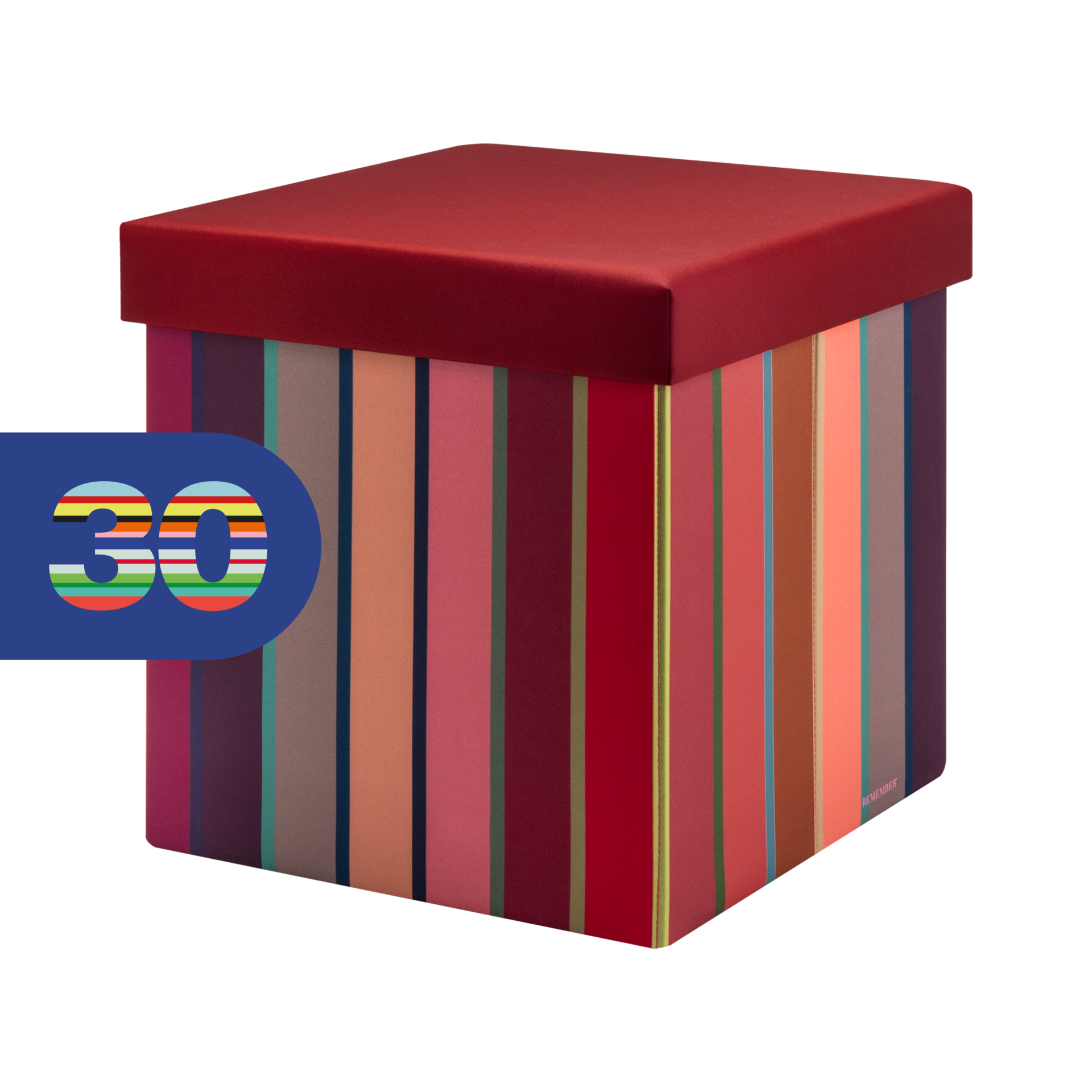 Würfelförmige Sitzbox mit dunkelrotem, gepolstertem Deckel. Seiten mit lebhaftem, vertikalem Streifenmuster in Rot, Rosa, Orange, Braun, Blau und Grün. Oben links blaues Etikett mit bunter Zahl „30“ („Remember 30“).