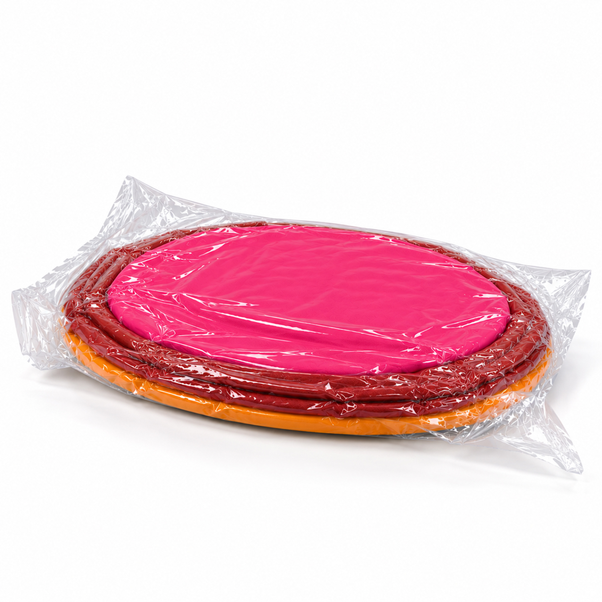 Runder Pouf „Pepe berry“ in drei leuchtenden Farben, vakuumiert und flach in transparenter Folie verpackt. Mit pinker Oberseite, beerenroter Mitte und orangefarbener Unterseite. Bezug leicht gewellt, bereit zur Entfaltung.