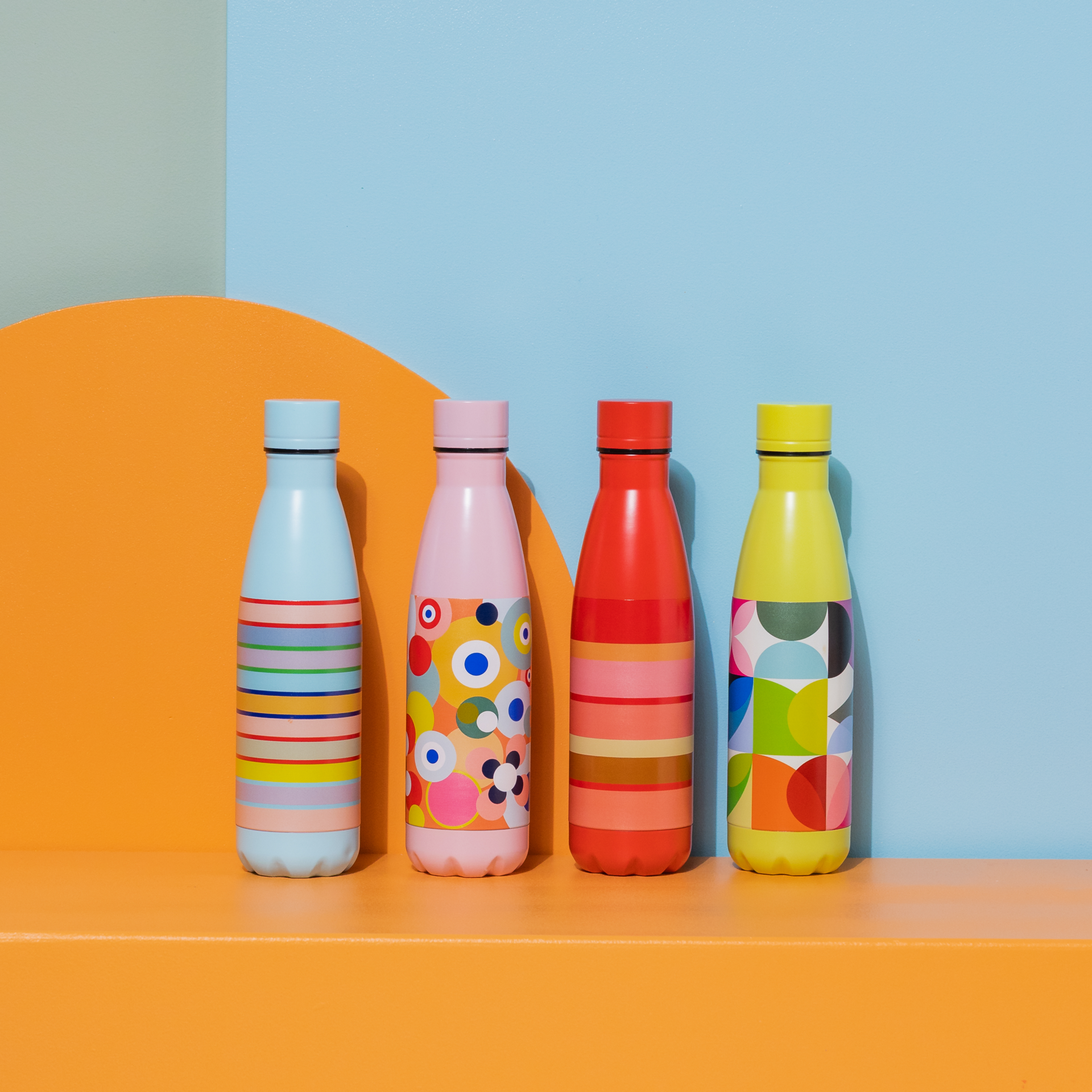Schmale, rote Edelstahl Trinkflasche mit bunten Streifen in Rosa-, Beige- und Orangetönen. Links daneben blaues Feld mit der Zahl 30 in bunten Streifen.
