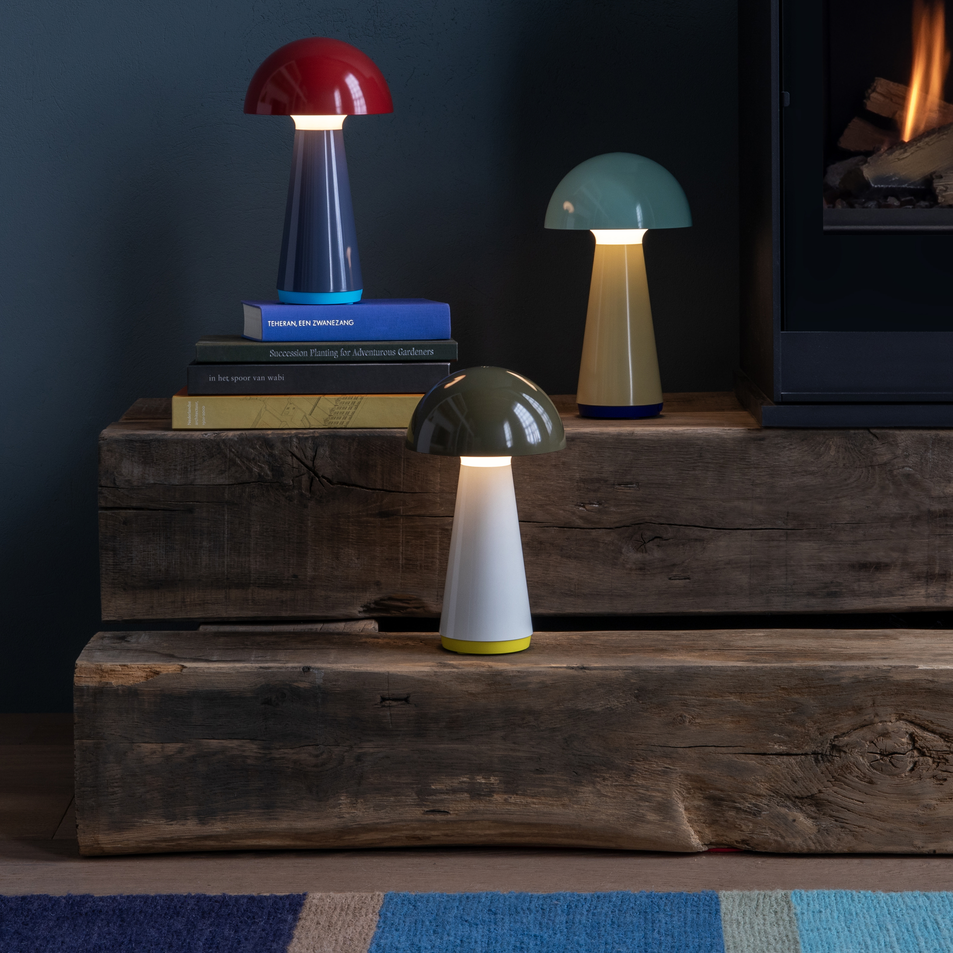 Una lámpara de mesa Bob de color verde oliva con pantalla en forma de seta, una base cónica de color beige y un zócalo amarillo.